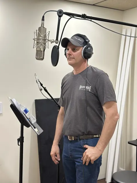 Fred Winston recording in the studio with headphones